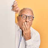 Shocked man peeking out from behind a wall - will your power bill increase soon? 